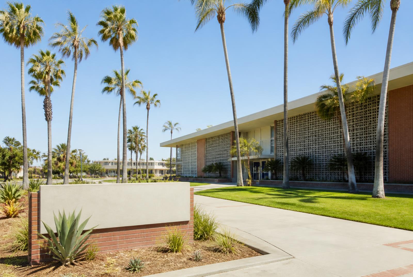 Sunlit palm-tree lined entrance of a classic Southern California high school campus